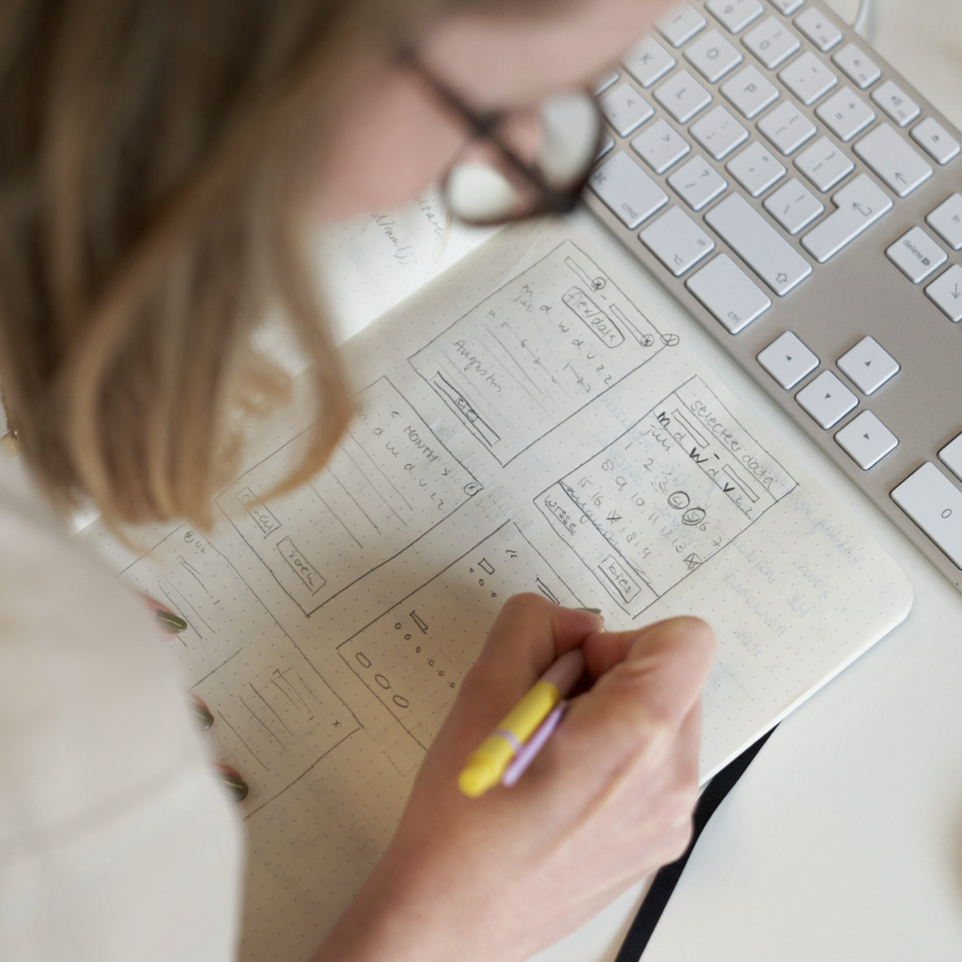 A person sketching out design wireframes in a notebook